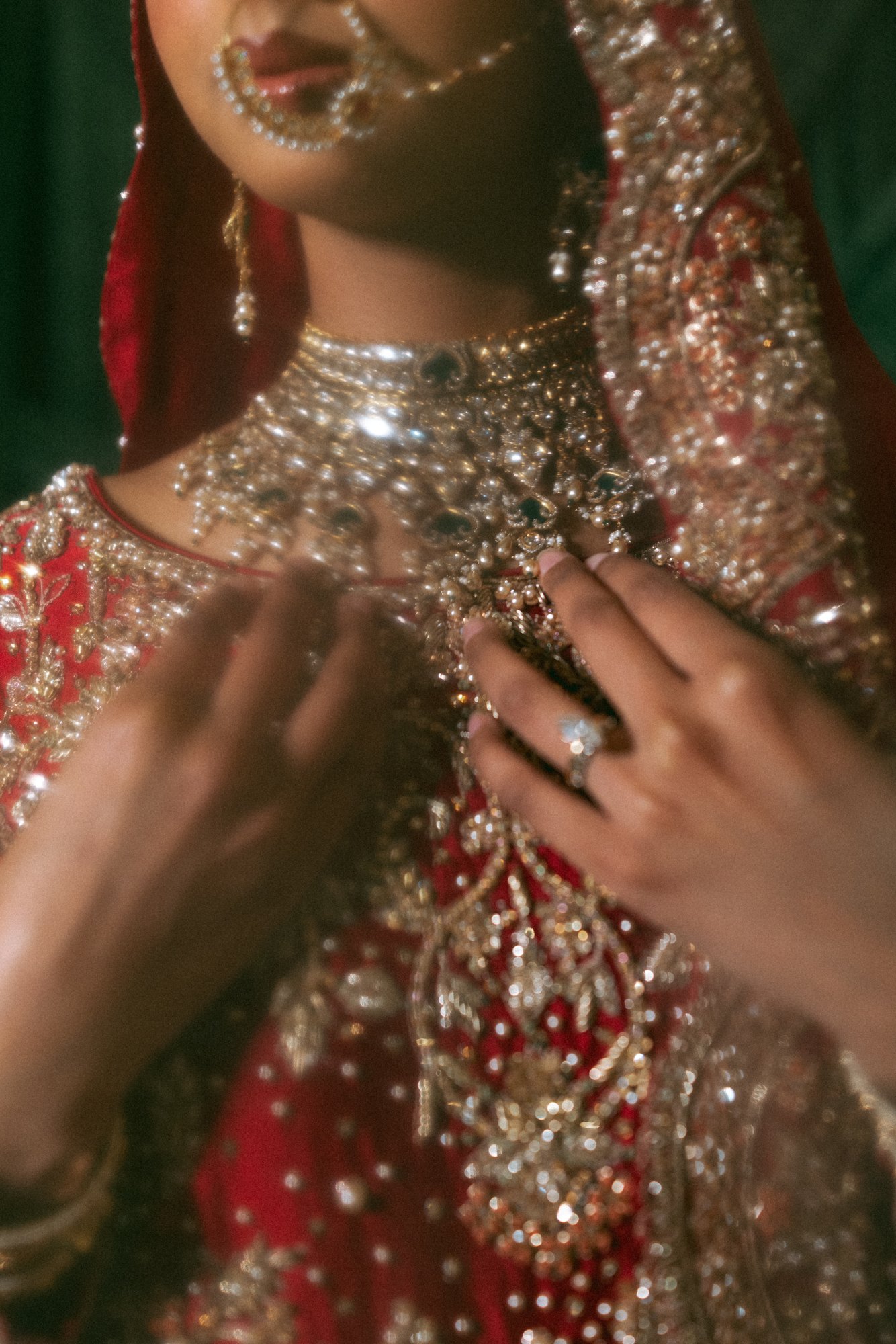 A bride’s wedding jewellery and embroidered outfit in warm light