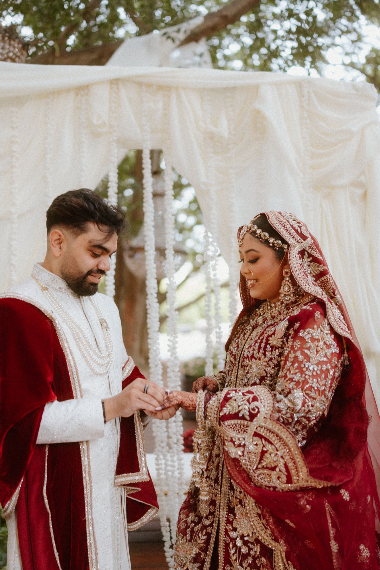 A couple exchanging vows beneath a canopy